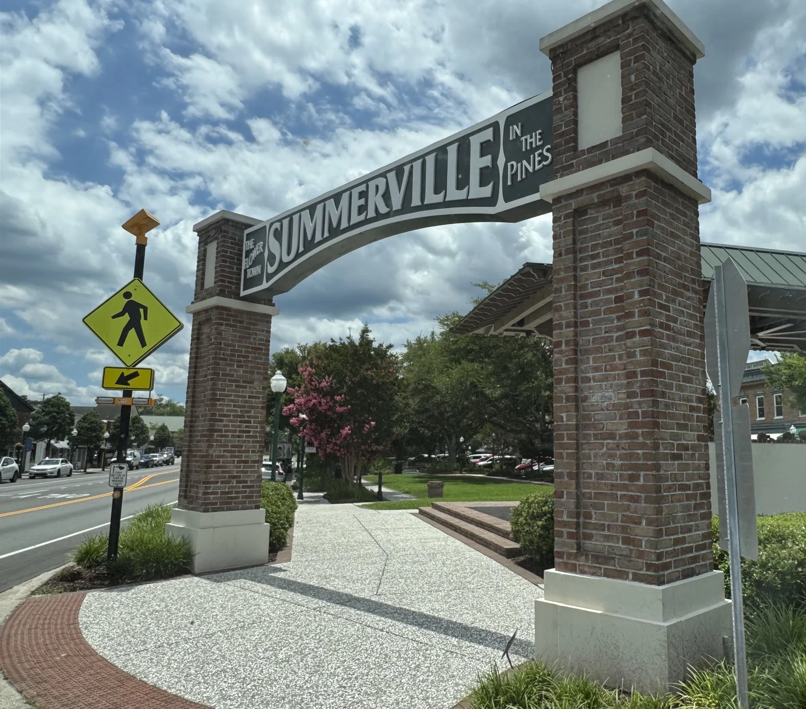 Summerville gateway sign between brick pillars at Hutchinson Square, with the pavilion behind it.